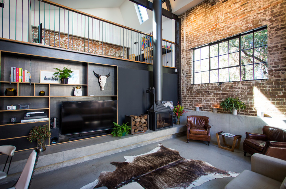 Photo of an expansive industrial loft-style living room in Sydney with black walls, concrete floors, a corner fireplace, a concrete fireplace surround and a built-in media wall.