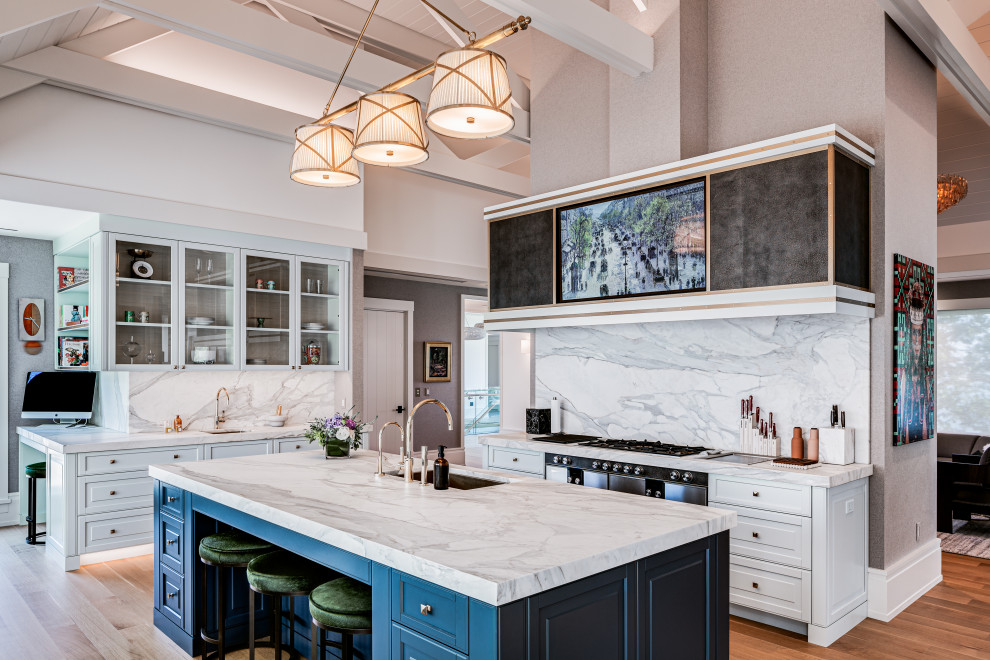 Exempel på ett maritimt flerfärgad flerfärgat kök, med en undermonterad diskho, luckor med upphöjd panel, vita skåp, marmorbänkskiva, flerfärgad stänkskydd, stänkskydd i marmor, rostfria vitvaror, mellanmörkt trägolv, en köksö och brunt golv