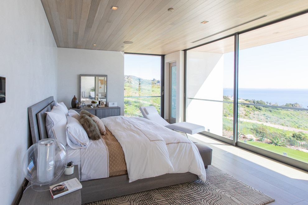 Photo of a modern bedroom in Los Angeles with beige walls, light hardwood floors and beige floor.