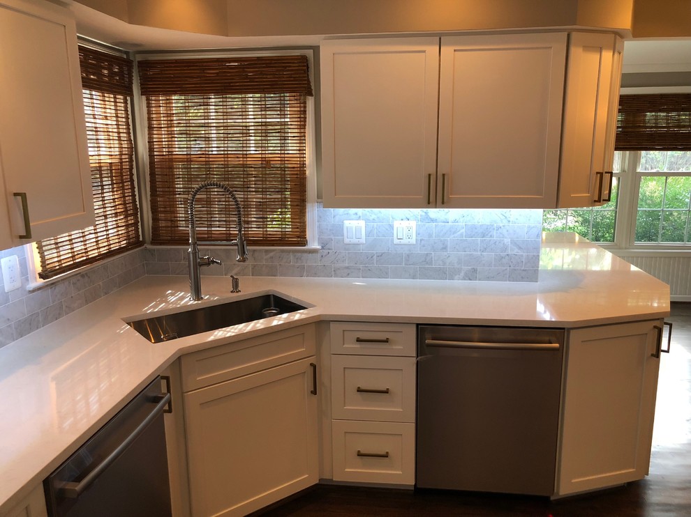 Inspiration for a mid-sized transitional u-shaped dark wood floor and brown floor eat-in kitchen remodel in DC Metro with an undermount sink, recessed-panel cabinets, white cabinets, quartz countertops, white backsplash, marble backsplash, stainless steel appliances, an island and white countertops