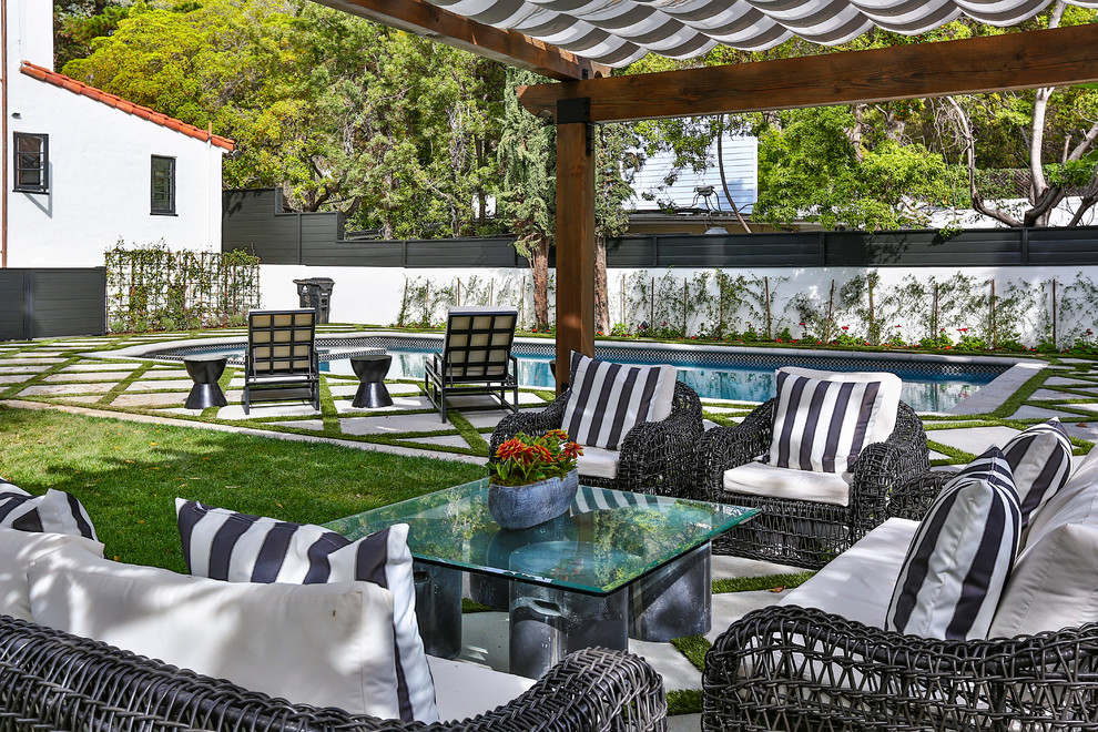 This is an example of a large mediterranean backyard patio in Los Angeles with an awning.
