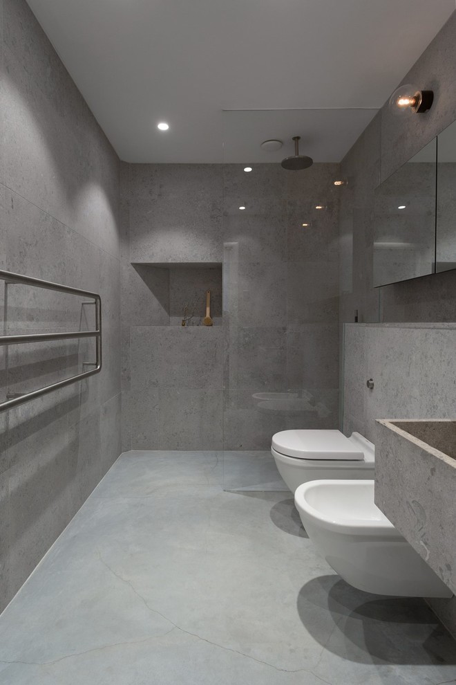 Inspiration for a mid-sized modern master bathroom in Other with an alcove shower, gray tile, grey walls, concrete floors, concrete benchtops, a bidet and a trough sink.