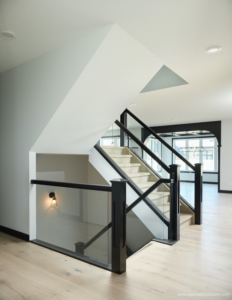 Inspiration for a modern carpeted u-shaped staircase in Edmonton with carpet risers and glass railing.