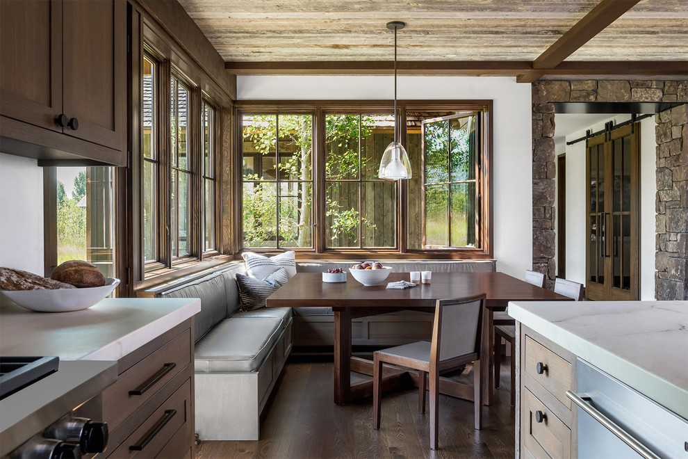 Mountain style dark wood floor and brown floor kitchen/dining room combo photo with white walls
