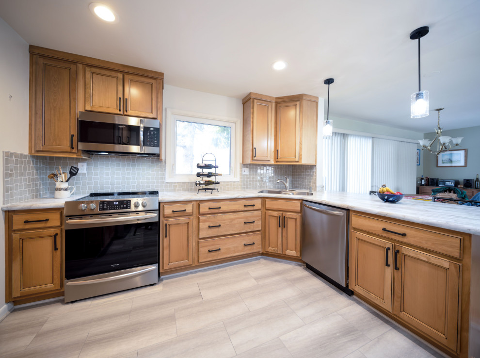 Inspiration for a mid-sized transitional l-shaped light wood floor and gray floor eat-in kitchen remodel with an integrated sink, recessed-panel cabinets, light wood cabinets, laminate countertops, gray backsplash, porcelain backsplash, stainless steel appliances, a peninsula and white countertops