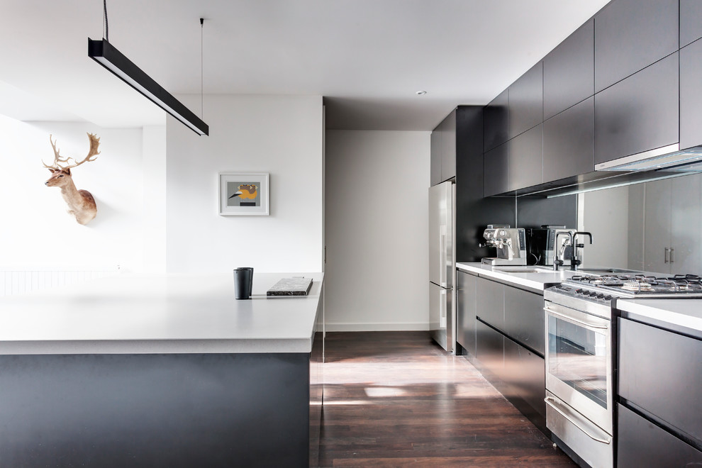 Inspiration for a mid-sized contemporary kitchen in Melbourne with an undermount sink, black cabinets, quartz benchtops, mirror splashback, stainless steel appliances, dark hardwood floors, with island and flat-panel cabinets.