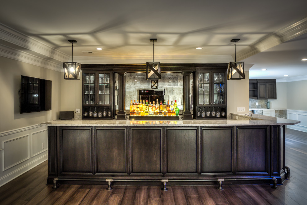 Photo of a large transitional l-shaped wet bar in New York with a drop-in sink, glass-front cabinets, dark wood cabinets, granite benchtops, grey splashback, glass tile splashback, porcelain floors, brown floor and beige benchtop.
