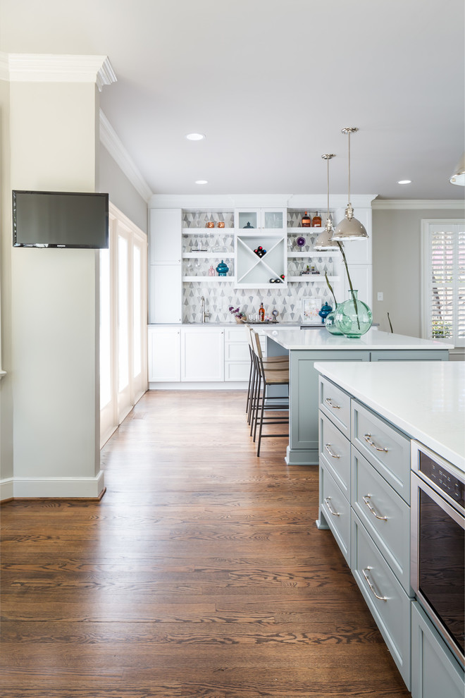 Inspiration for a huge transitional galley medium tone wood floor open concept kitchen remodel in Raleigh with a farmhouse sink, flat-panel cabinets, white cabinets, quartz countertops, gray backsplash, ceramic backsplash, stainless steel appliances and two islands