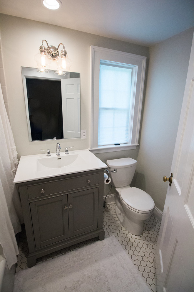 Mid-sized transitional 3/4 pebble tile floor corner bathtub photo in Boston with shaker cabinets, gray cabinets, a two-piece toilet, white walls, an undermount sink and solid surface countertops