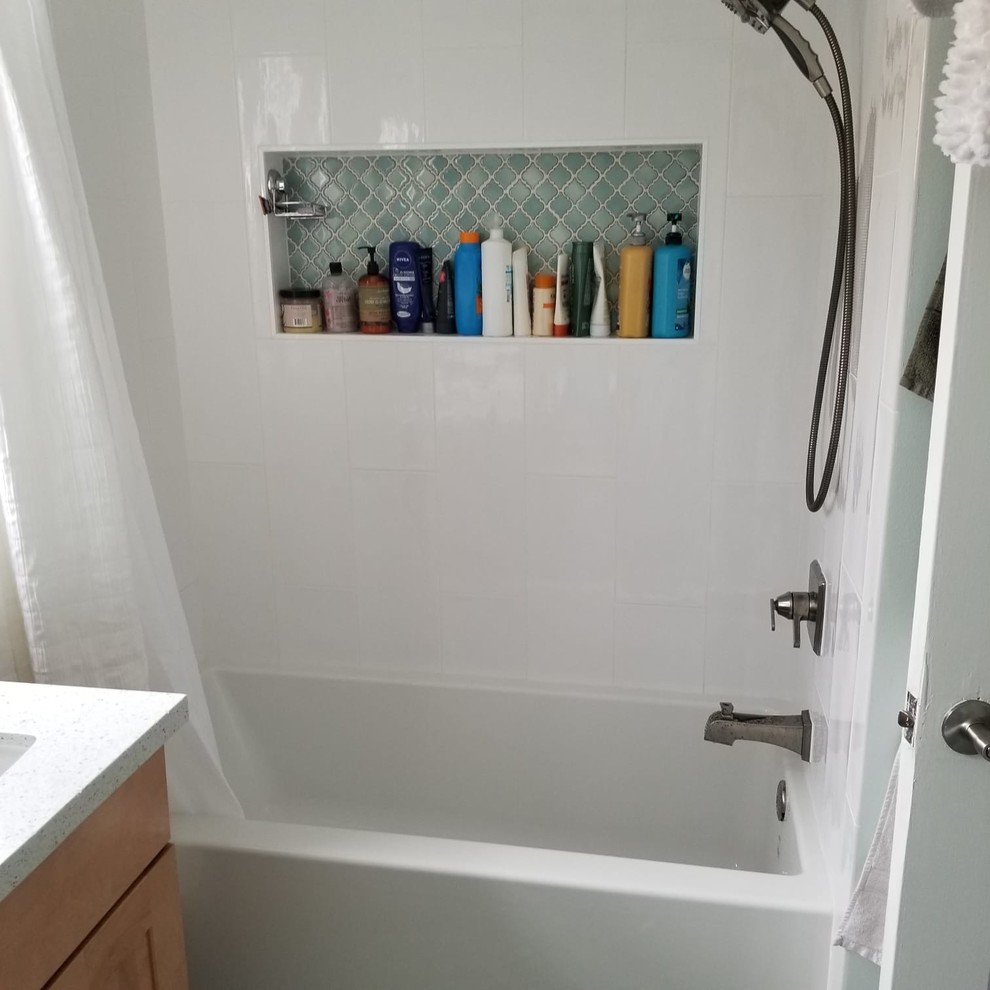 This is an example of a mid-sized transitional 3/4 bathroom in San Francisco with shaker cabinets, light wood cabinets, an alcove tub, a shower/bathtub combo, white tile, ceramic floors, an undermount sink, recycled glass benchtops, green floor, a shower curtain, white benchtops, a two-piece toilet and green walls.