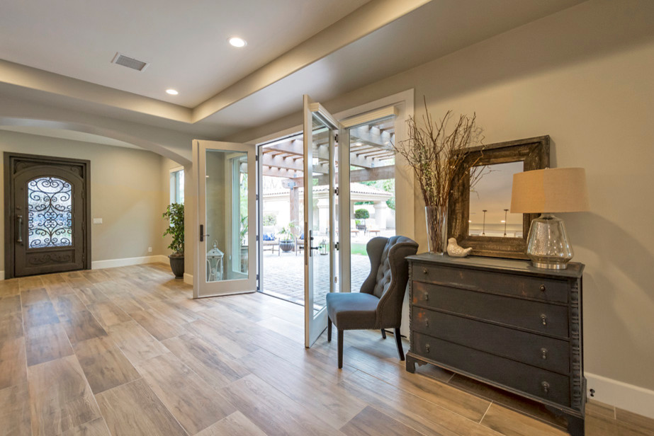 Example of a large transitional porcelain tile and brown floor single front door design in Phoenix with brown walls and a black front door