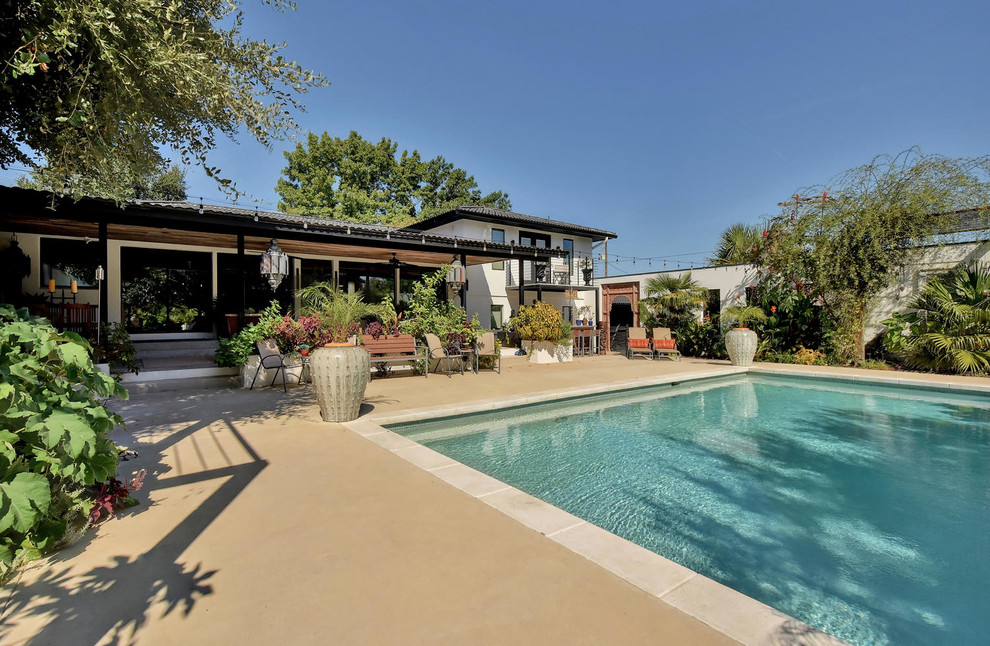Mid-sized transitional backyard concrete and rectangular natural pool house photo in Austin