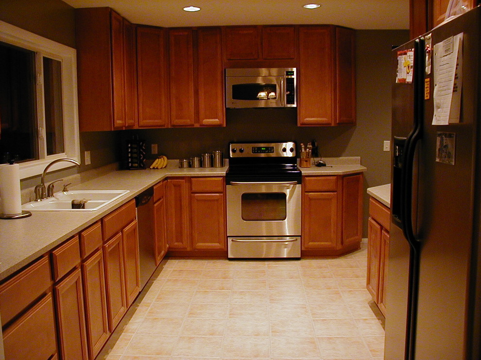 Inspiration for a mid-sized galley ceramic tile enclosed kitchen remodel in Denver with a double-bowl sink, light wood cabinets, laminate countertops, stainless steel appliances and gray walls
