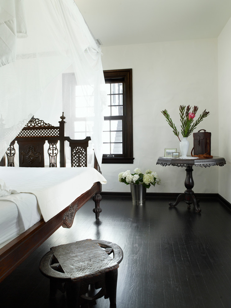 Design ideas for a mediterranean bedroom in Miami with white walls, dark hardwood floors and black floor.