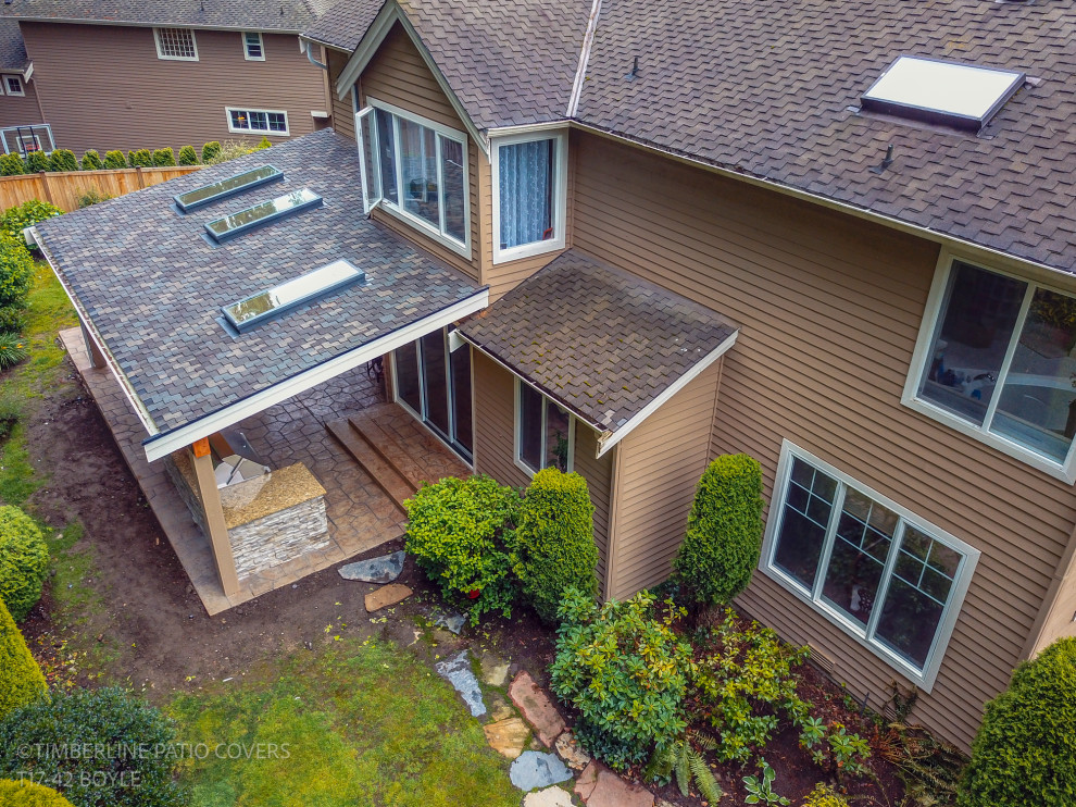Patio kitchen - mid-sized contemporary backyard stamped concrete patio kitchen idea in Seattle with a roof extension