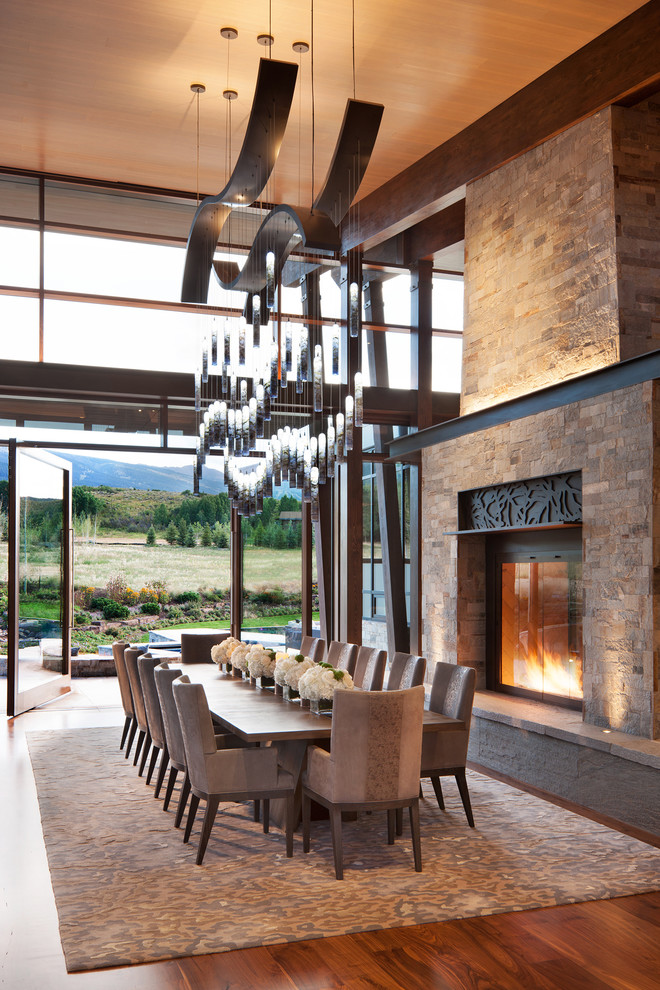 Photo of an expansive country kitchen/dining combo in Denver with a two-sided fireplace and a stone fireplace surround.