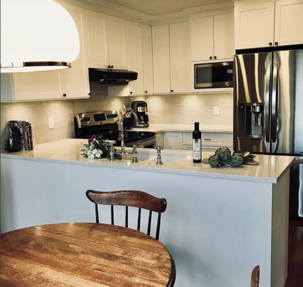 Mid-sized transitional u-shaped dark wood floor and brown floor eat-in kitchen photo in Ottawa with a drop-in sink, white cabinets, quartz countertops, white backsplash, glass tile backsplash, stainless steel appliances and two islands