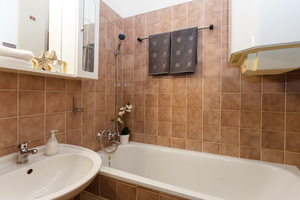 Photo of a small contemporary 3/4 bathroom in Other with a wall-mount sink, raised-panel cabinets, white cabinets, a one-piece toilet, brown tile, ceramic tile, white walls and ceramic floors.