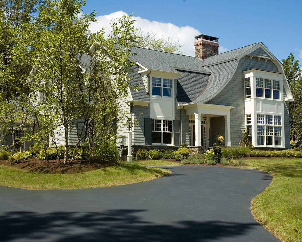 This is an example of a large arts and crafts two-storey grey house exterior in New York with wood siding, a gambrel roof and a shingle roof.