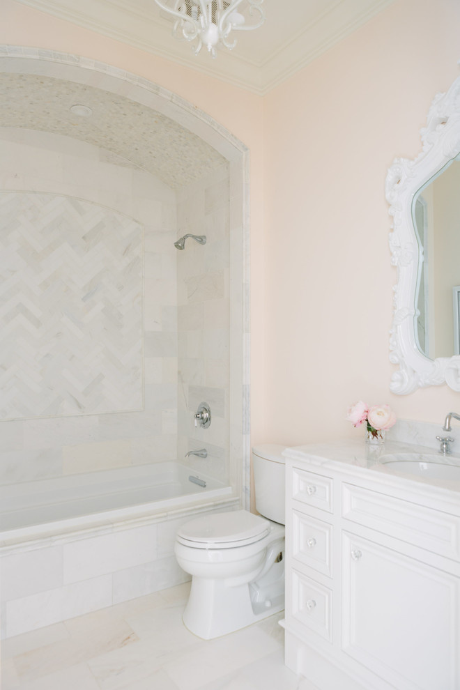 Transitional bathroom in Chicago with furniture-like cabinets, white cabinets, an alcove tub, a shower/bathtub combo, a two-piece toilet, pink tile, blue walls, porcelain floors, an undermount sink, marble benchtops, white floor, an open shower and white benchtops.