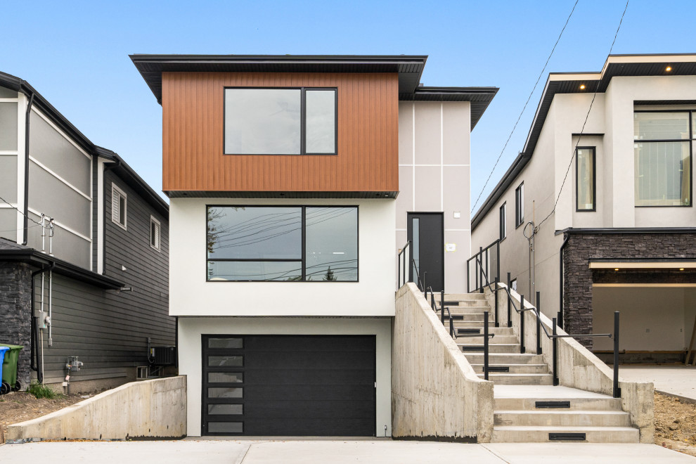 Design ideas for an expansive modern two-storey multi-coloured exterior in Calgary with mixed siding and a flat roof.