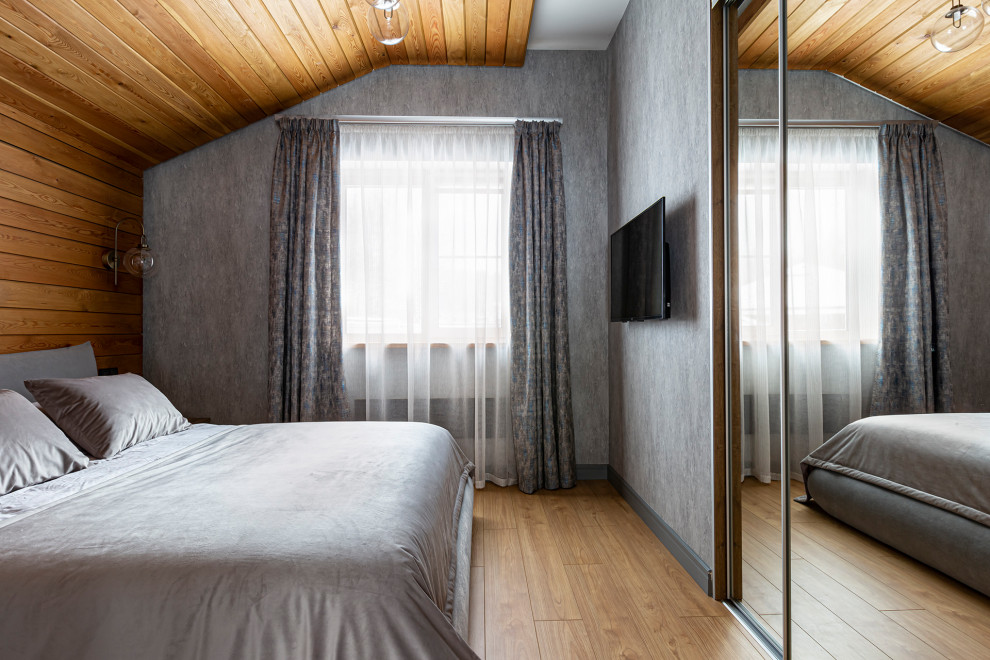 Imagen de dormitorio contemporáneo pequeño con paredes grises, suelo laminado, suelo amarillo, machihembrado y madera