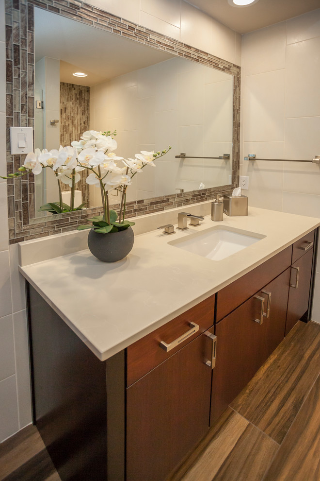 Small contemporary 3/4 bathroom in Dallas with flat-panel cabinets, dark wood cabinets, an alcove shower, a one-piece toilet, brown tile, gray tile, matchstick tile, white walls, porcelain floors, an undermount sink, engineered quartz benchtops, brown floor and a hinged shower door.