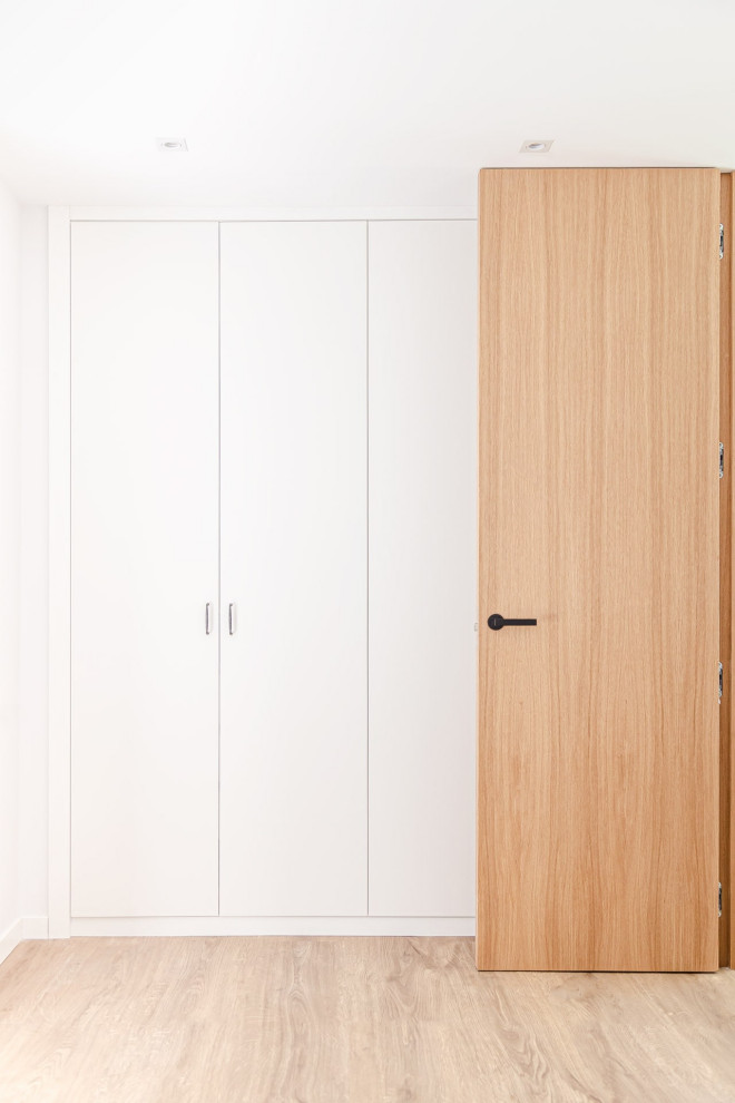 Esempio di una camera degli ospiti minimalista di medie dimensioni con pareti bianche, pavimento in vinile, pavimento marrone e soffitto ribassato