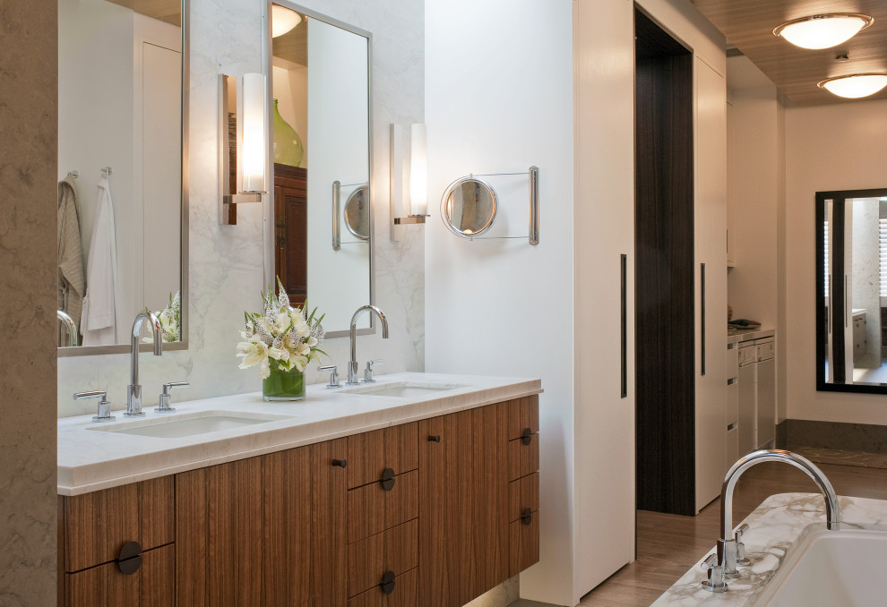 Exemple d'une salle de bain principale chic avec un placard à porte plane, des portes de placard beiges, du carrelage en marbre, un mur blanc, un sol en bois brun, un sol marron, un plan de toilette blanc, meuble double vasque et meuble-lavabo suspendu.