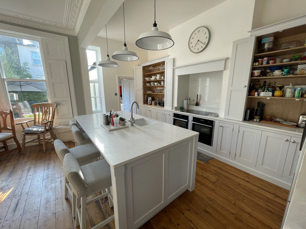 This is an example of a traditional kitchen in Other with a drop-in sink, shaker cabinets, white cabinets and with island.