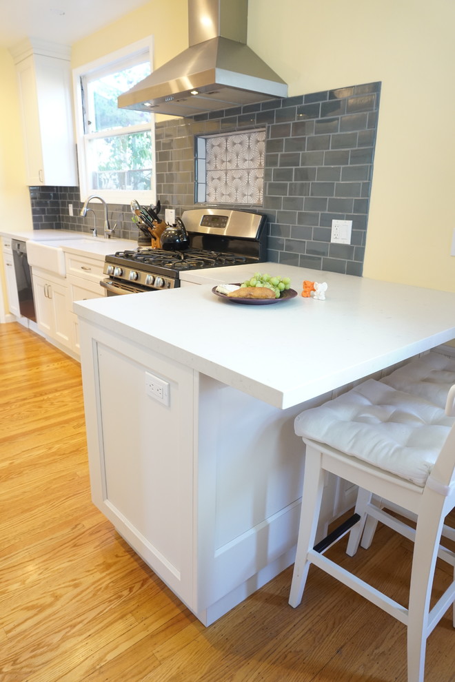 Photo of a mid-sized transitional galley separate kitchen in San Francisco with shaker cabinets, white cabinets, marble benchtops, grey splashback, ceramic splashback, stainless steel appliances and light hardwood floors.