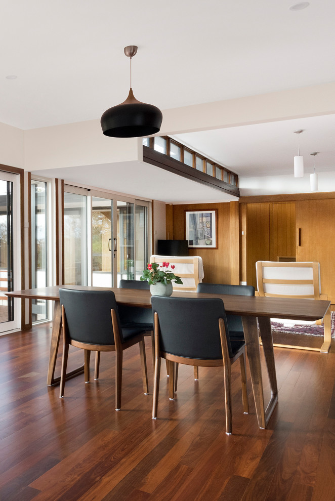 Mid-sized contemporary open plan dining in Canberra - Queanbeyan with white walls, dark hardwood floors, brown floor and wood walls.