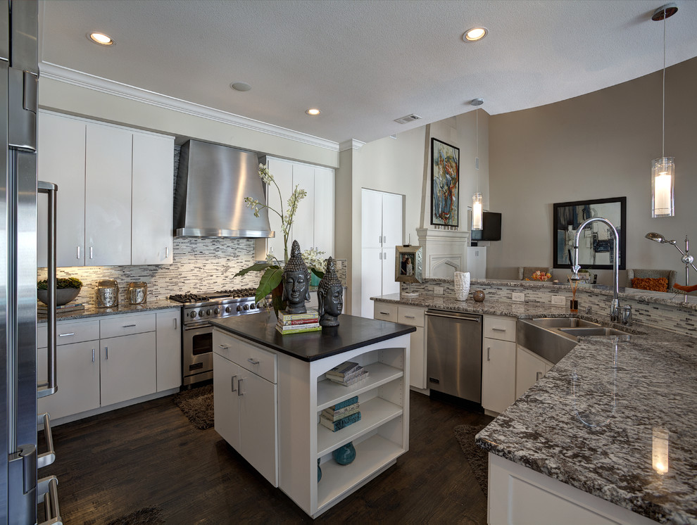 Large mediterranean u-shaped open plan kitchen in Dallas with a farmhouse sink, flat-panel cabinets, white cabinets, multi-coloured splashback, matchstick tile splashback, stainless steel appliances, dark hardwood floors and with island.