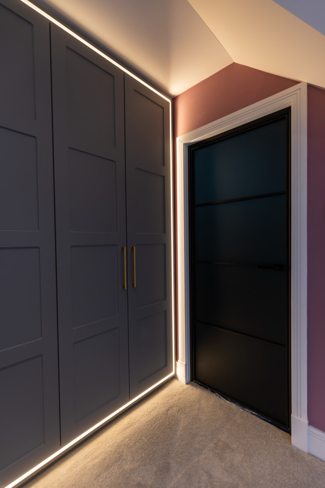 На фото: встроенный шкаф среднего размера, унисекс в современном стиле с фасадами в стиле шейкер, серыми фасадами, ковровым покрытием и бежевым полом