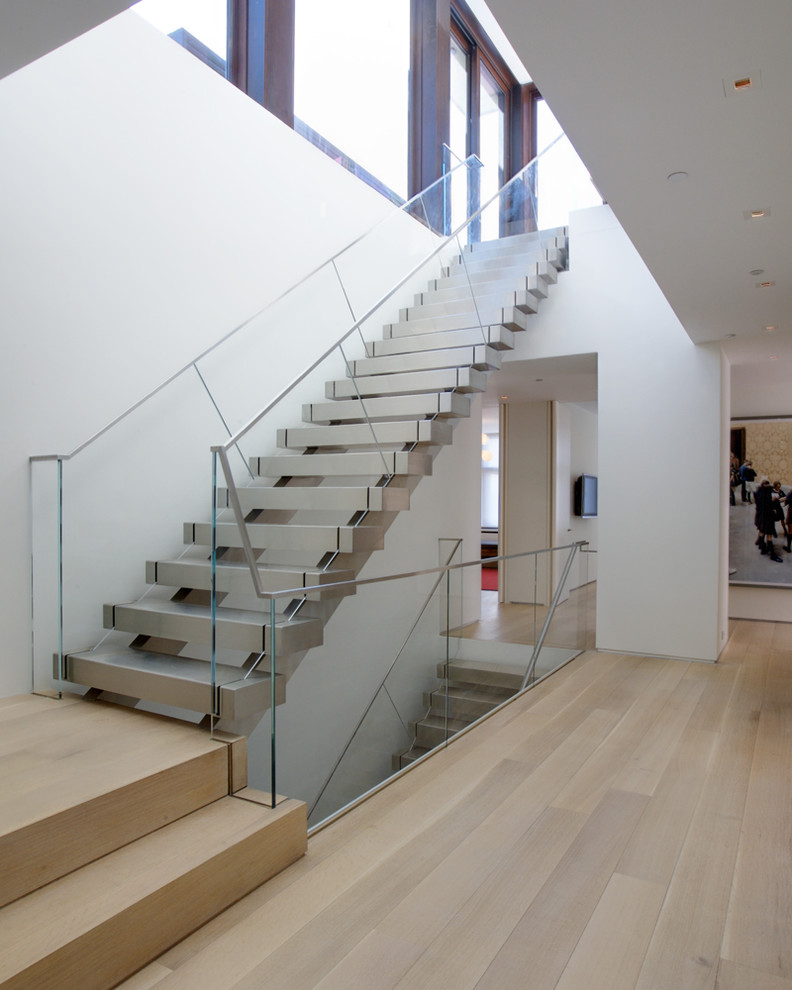 This is an example of a contemporary floating staircase in New York with glass railing.