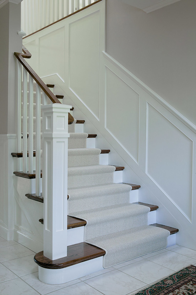 Large transitional wood l-shaped staircase in San Francisco with painted wood risers.