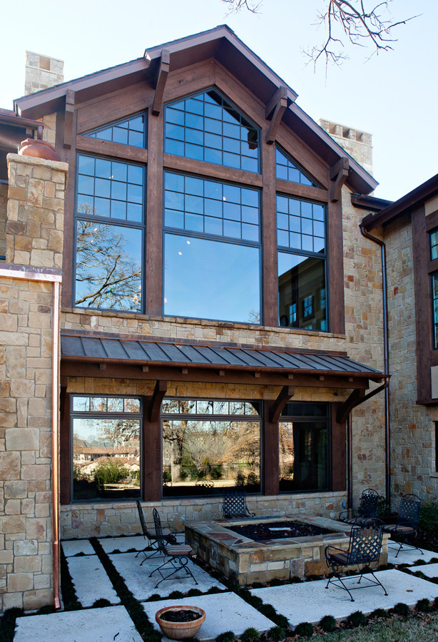 Photo of a country two-storey exterior in Dallas with stone veneer.