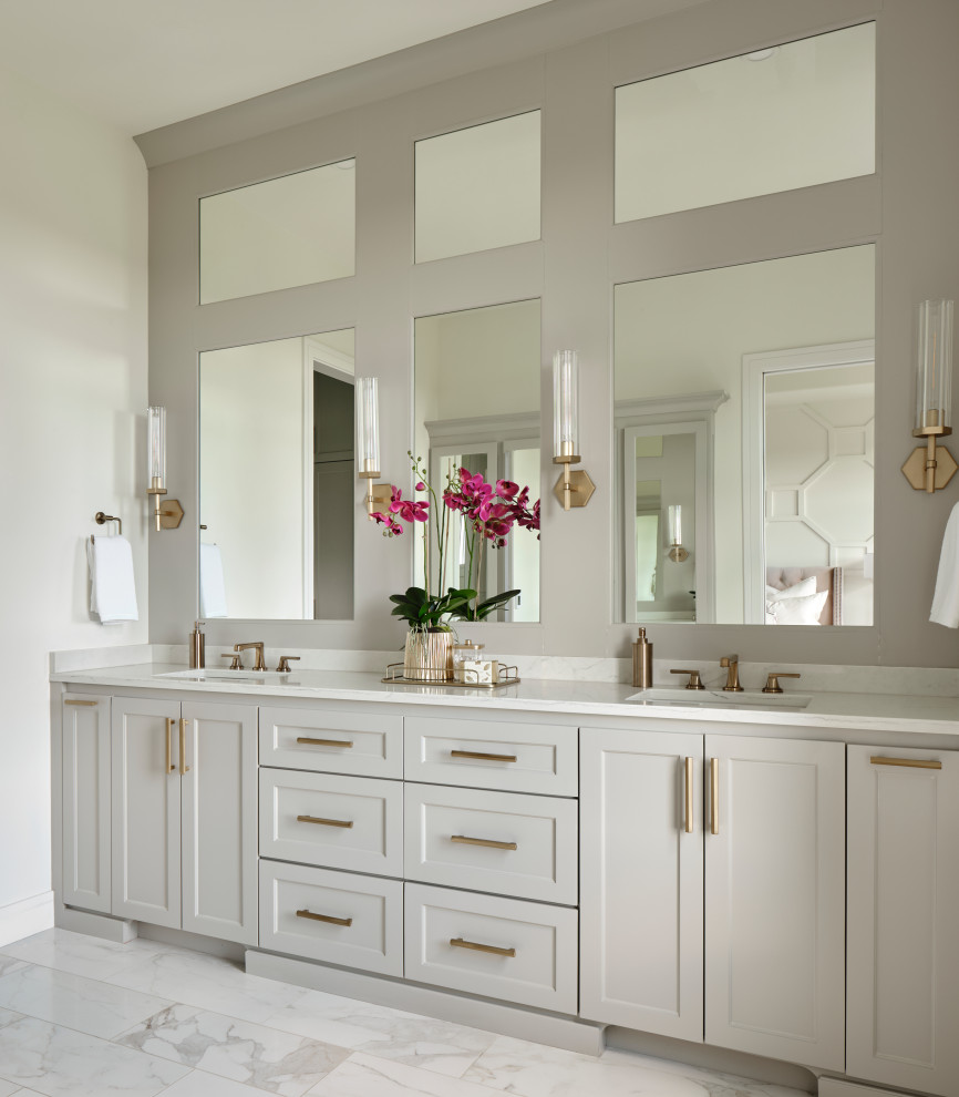 На фото: главная ванная комната среднего размера в стиле неоклассика (современная классика) с фасадами в стиле шейкер, серыми фасадами, душем в нише, унитазом-моноблоком, белой плиткой, белыми стенами, полом из керамогранита, врезной раковиной, столешницей из искусственного кварца, разноцветным полом, душем с распашными дверями, белой столешницей, сиденьем для душа, тумбой под две раковины и встроенной тумбой с