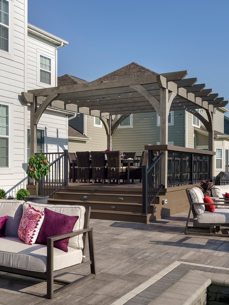 Design ideas for an expansive eclectic backyard patio in Columbus with a fire feature, brick pavers and a pergola.