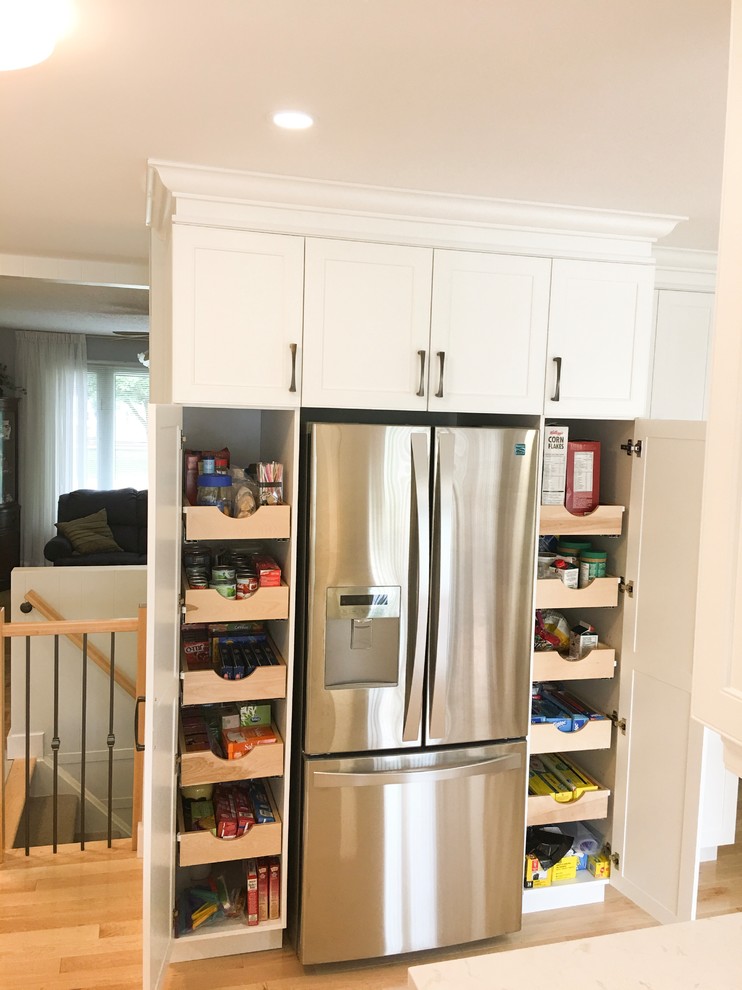Inspiration for a mid-sized contemporary u-shaped light wood floor and brown floor eat-in kitchen remodel with a single-bowl sink, shaker cabinets, white cabinets, quartz countertops, beige backsplash, marble backsplash, stainless steel appliances and no island