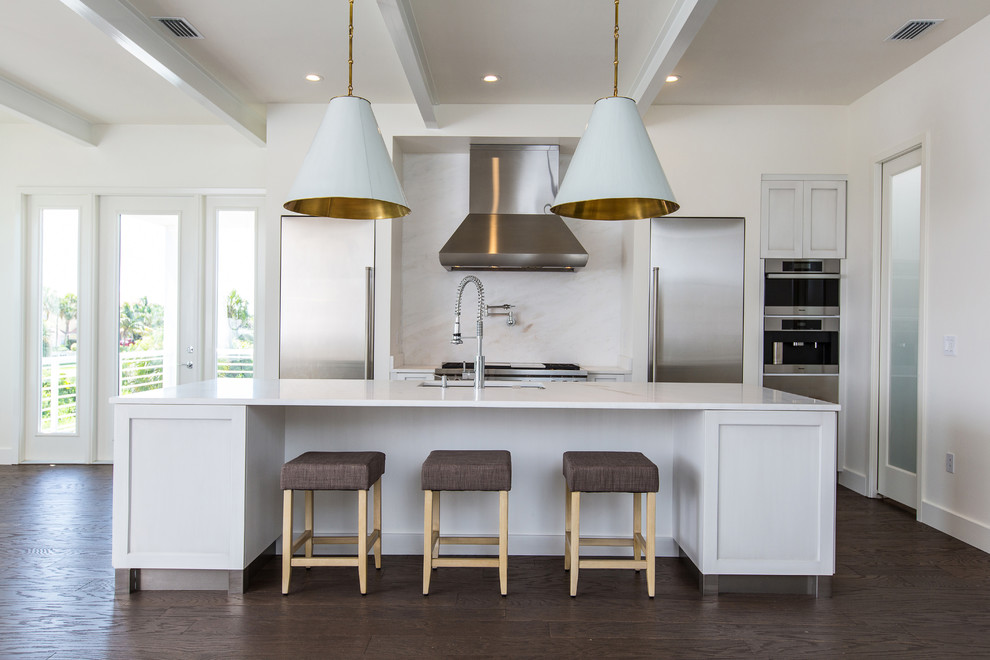 Inspiration for a contemporary galley kitchen in Orlando with an undermount sink, shaker cabinets, white cabinets, white splashback, stainless steel appliances, dark hardwood floors and with island.