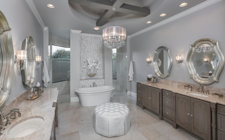 Inspiration for an expansive traditional master bathroom in Tampa with raised-panel cabinets, brown cabinets, a freestanding tub, a curbless shower, gray tile, grey walls, an undermount sink, beige floor and a hinged shower door.