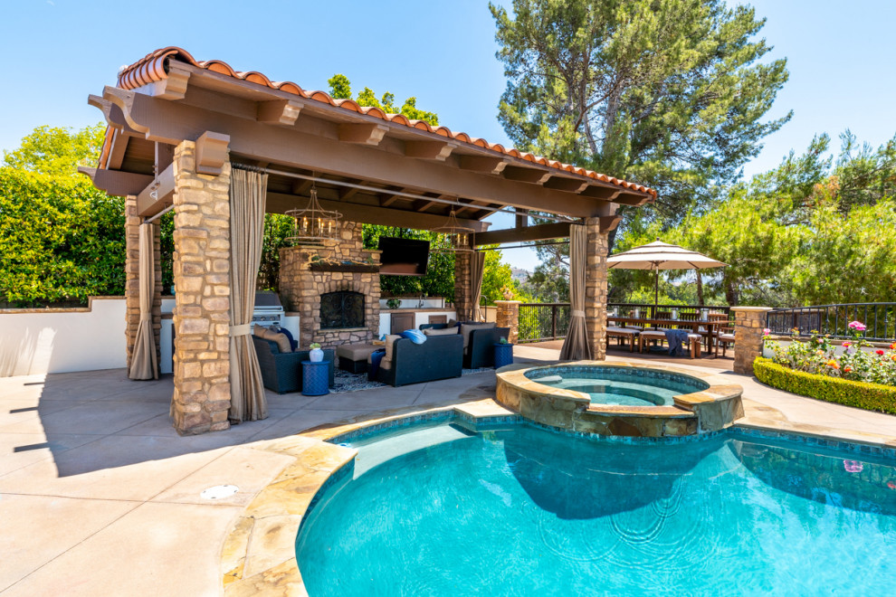 This is an example of a large mediterranean backyard kidney-shaped pool in Los Angeles with a hot tub.