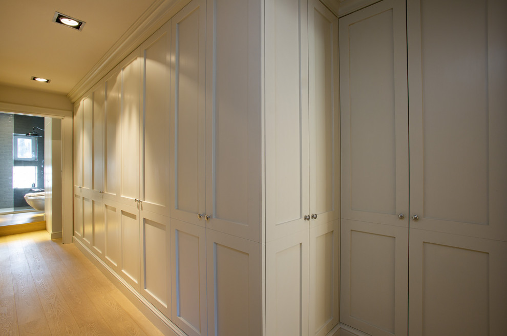Modelo de recibidores y pasillos clásicos de tamaño medio con paredes beige, suelo de madera clara, bandeja y madera