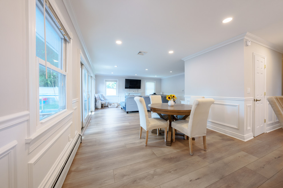 Idee per una sala da pranzo aperta verso il soggiorno moderna di medie dimensioni con pareti bianche, pavimento in vinile, pavimento beige e boiserie