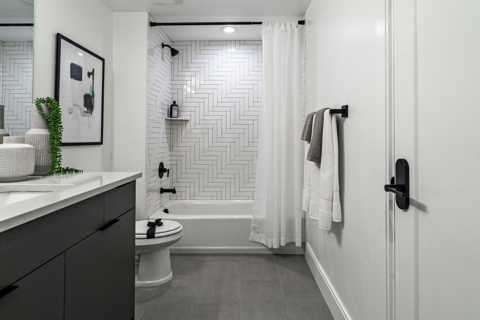 Cette image montre une salle de bain minimaliste de taille moyenne avec une baignoire en alcôve, un combiné douche/baignoire, un carrelage blanc, des carreaux en allumettes, un mur blanc, un sol en vinyl, un lavabo encastré, un sol gris, une cabine de douche avec un rideau, un plan de toilette blanc et meuble simple vasque.