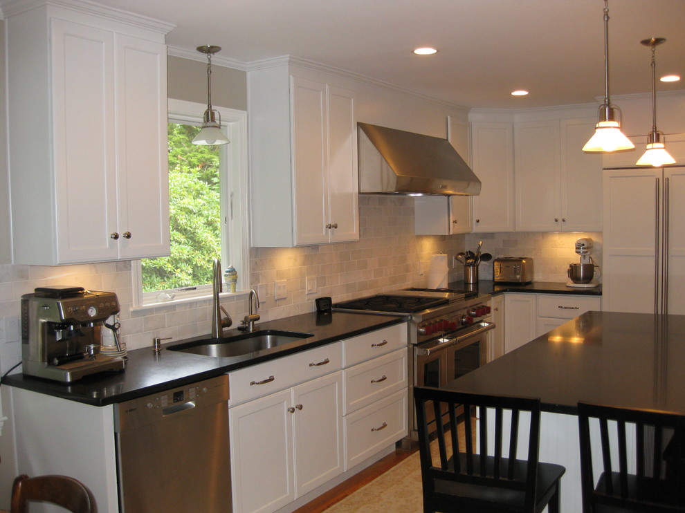 Eat-in kitchen - transitional u-shaped medium tone wood floor eat-in kitchen idea in Boston with an undermount sink, recessed-panel cabinets, white cabinets, gray backsplash, subway tile backsplash, stainless steel appliances, an island and black countertops