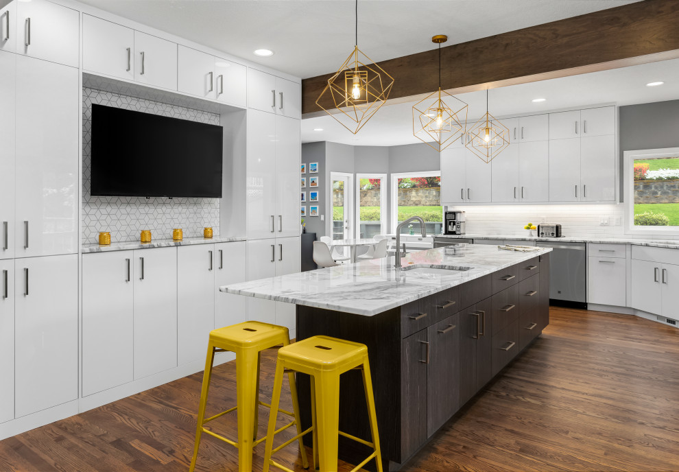 Large trendy l-shaped medium tone wood floor, brown floor and exposed beam eat-in kitchen photo in Portland with an undermount sink, flat-panel cabinets, white cabinets, marble countertops, white backsplash, ceramic backsplash, stainless steel appliances, an island and white countertops