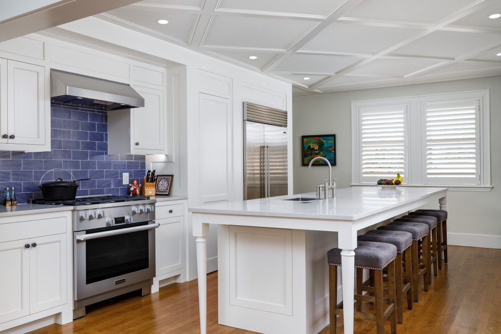 Inspiration for a transitional galley separate kitchen in Birmingham with an undermount sink, beaded inset cabinets, white cabinets, quartz benchtops, blue splashback, stainless steel appliances, medium hardwood floors, with island, brown floor, white benchtop and coffered.