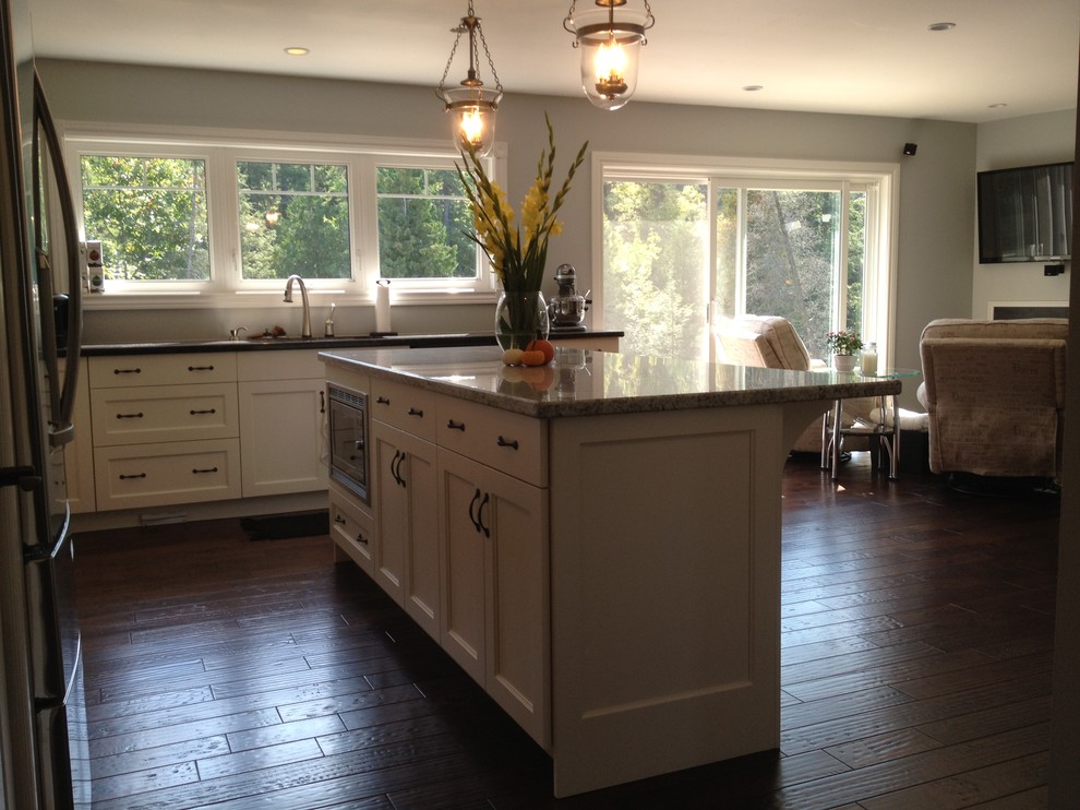 Mid-sized transitional l-shaped medium tone wood floor kitchen pantry photo in Toronto with a double-bowl sink, shaker cabinets, white cabinets, quartzite countertops, stainless steel appliances and an island